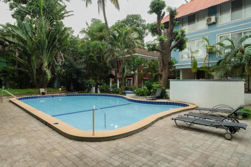 a large swimming pool in front of a building at The Bumblebee- Serene 3BHK Villa- Candolim, Goa By StayMonkey in Candolim