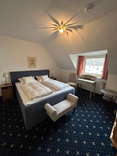 a bedroom with a large bed with a ceiling fan at Hotel Fabritz in Essen