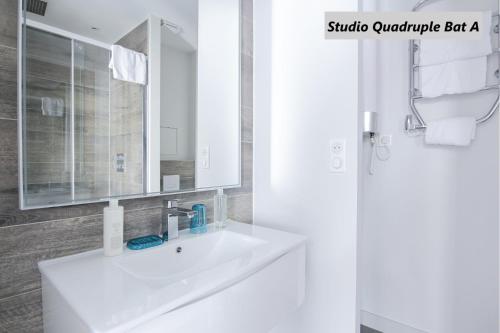 ein Badezimmer mit einem weißen Waschbecken und einem Spiegel in der Unterkunft Apparts de l'Oncle Louis in Versailles