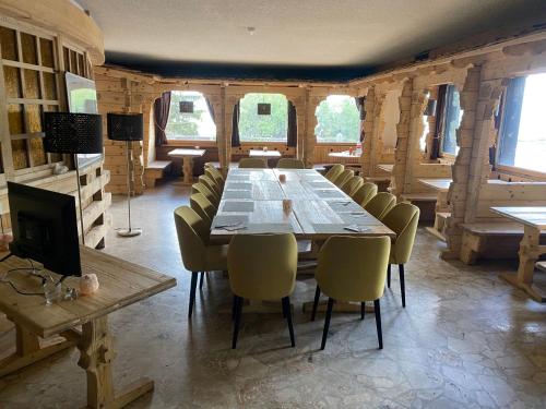 jadalnia z długim stołem i krzesłami w obiekcie Auberge de l'Ours w mieście Les Collons