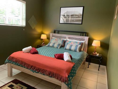 una camera con un letto con una coperta rossa di Carmel Huys a Città del Capo
