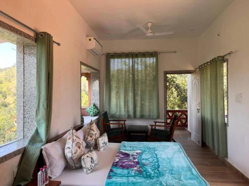 a room with a bed and a couch and windows at Kumbhalmer Private pool villa in Ranakpur