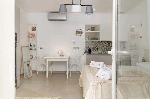 a white room with a bed and a table at MandorloCarrubo's suite in Ostuni