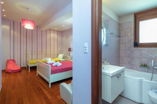 a bathroom with a bed and a tub and a sink at Newly Renovated Villa 4 Seasons with BBQ, private pool, ping pong and football table in Viranepiskopí