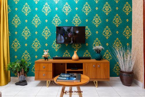 a living room with a tv on a green wall at Little Haven in Fort Portal