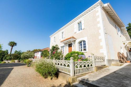a house with a white fence in front of it at Jouandeou in Donzacq