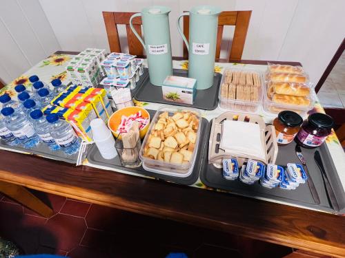una mesa con bandejas de comida y bebida en G & S - Hostel Vila do Conde, en Gião