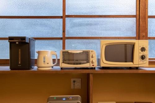 a shelf with a microwave and other appliances on it at こんぴら町家 Konpira Machiya in Kotohira