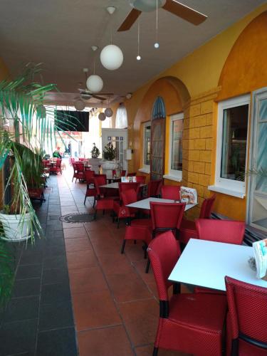 a restaurant with red chairs and tables in a room at Hotel Esplanade & Aparthotel Rialto in Binz