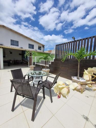 a patio with two chairs and a glass table at Pousada Coqueiral in Aracruz