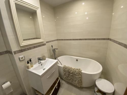 a bathroom with a white tub and a sink at Villa Romano in Manilva