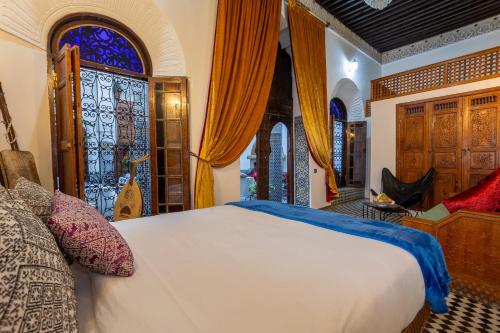 a bedroom with a bed and a stained glass window at Palais Nazha Fes - Luxury Lodging in Fès