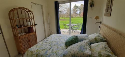a bedroom with a bed and a window with a table at gite à Harcourt in Harcourt