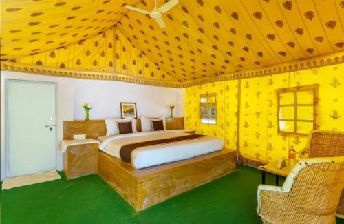 a bedroom with a bed in a yellow room at desert Safari Jaisalmer in Sām