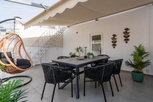 a dining room with a table and chairs on a balcony at Athens Hills, Boutique Apartments in Athens