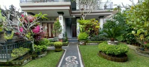 a garden in front of a house with plants at Umayuri Inn in Ubud