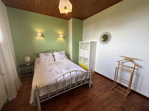 una camera con un letto in una stanza con pareti verdi di Madroles a Tartas