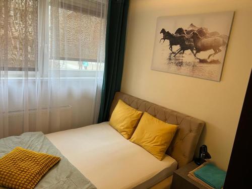 a living room with a couch and a picture of horses at Last Pub Rynek-Klima-ParkigFree-Netflix-YouTube in Wrocław