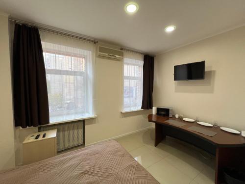 Zimmer mit einem Schreibtisch und einem TV an der Wand in der Unterkunft Апартаменти на Печерську in Kiew