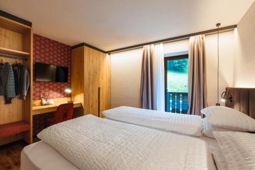 a hotel room with two beds and a window at Hotel Vioz in Peio Fonti