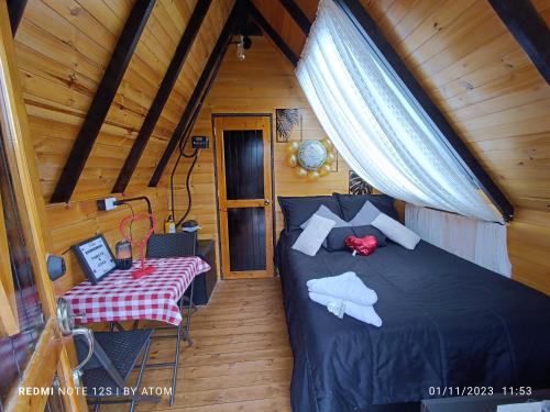 1 dormitorio con 1 cama y 1 mesa en una habitación en Glamping refugio Gaia, en Paipa