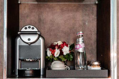 a shelf with a drink bottle and flowers on it at Bianca Maria Palace Hotel in Milan