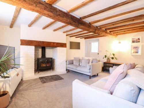 a living room with white furniture and a fireplace at 36 Main Street in Derby
