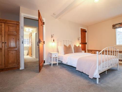 a bedroom with a large white bed and a doorway at 36 Main Street in Derby