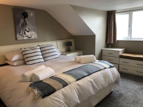 ein Schlafzimmer mit einem großen weißen Bett mit Kissen in der Unterkunft 5 Shore Street in Donaghadee