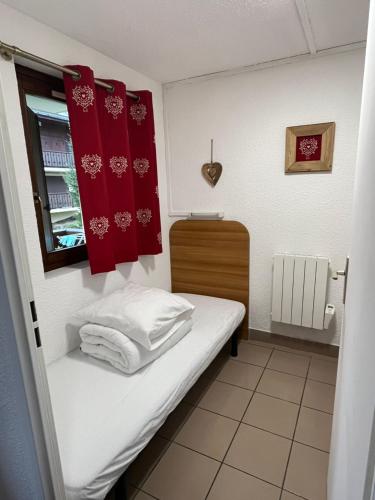 a small room with a bed and a window at L'Épicéa - Praz in Praz-sur-Arly