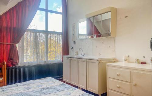 a bathroom with a sink and a bed and a window at 2 Bedroom Cozy Home In Noordwijkerhout in Noordwijkerhout