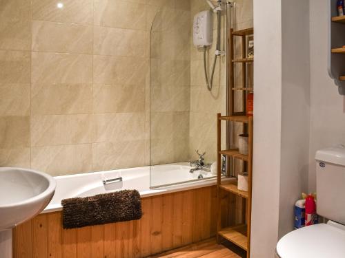 a bathroom with a tub and a sink and a toilet at The Winchester in Deal
