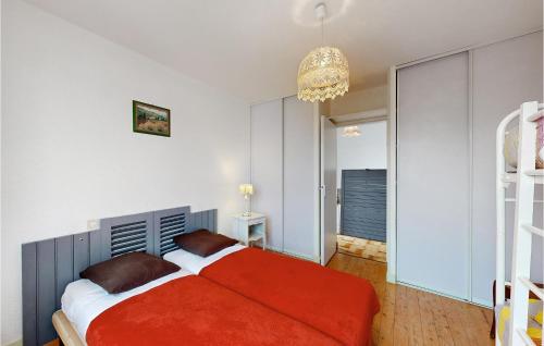 um quarto com uma cama vermelha e um lustre em 2 Bedroom Lovely Apartment In St-georges-de-didonne em Saint-Georges-de-Didonne