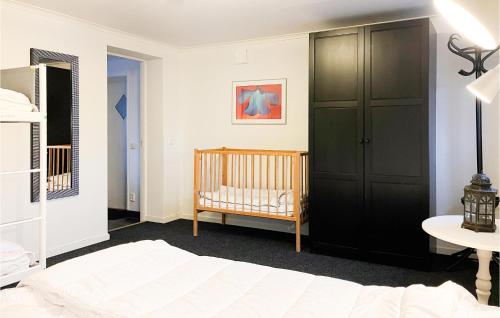 - une chambre avec un lit bébé et un placard noir dans l'établissement Gorgeous Apartment In Sdra Vi With Kitchen, à Södra Vi