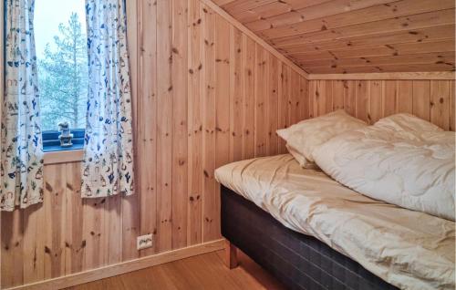 Cama en habitación de madera con ventana en 4 Bedroom Amazing Home In Vatnestrm, en Svaland