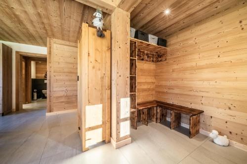 um quarto vazio com uma parede de madeira com um banco em Le Chalet des Praz em Abondance