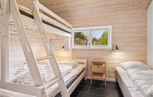 FjellerupにあるAmazing Home In Glesborg With 4 Bedrooms And Wifiの窓付きの小さな部屋の二段ベッド2台分です。