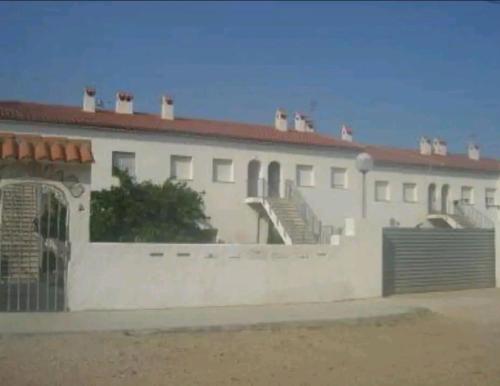 a white building with a fence in front of it at Piso California 3 aire acondicionado, wifi, cerca del mar in Miami Platja