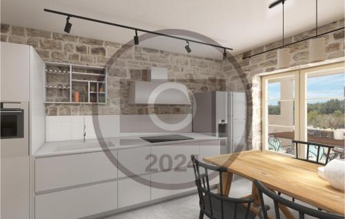 a kitchen with white cabinets and a wooden table at Gorgeous Home In Sinj With Kitchen in Sinj