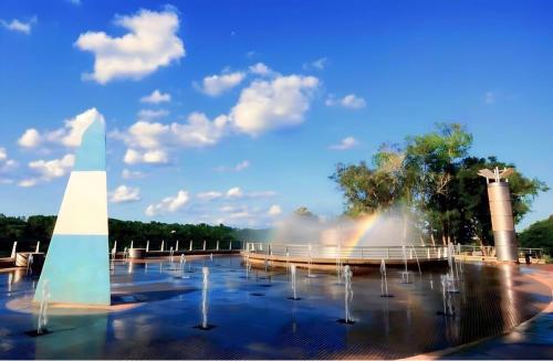 una fuente con un arco iris en un parque en Deptos Doña Benigna en Puerto Iguazú