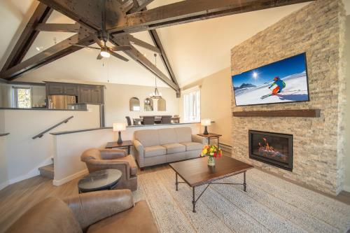 a living room with a couch and a fireplace at Soda Spring 1910 by SummitCove Lodging in Keystone