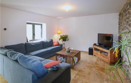 un salon avec un canapé bleu et une télévision dans l'établissement Stunning Home In Darbres, à Darbres