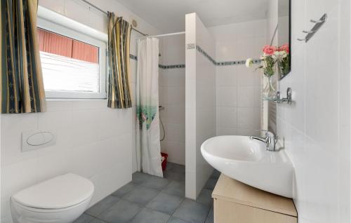 Baño blanco con aseo y lavamanos en 2 Bedroom Lovely Apartment In Krus, en Kruså