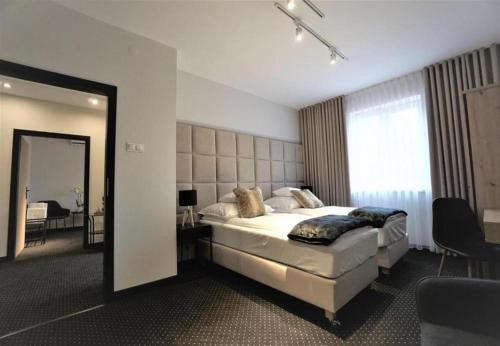 ein Schlafzimmer mit einem großen Bett und einem Spiegel in der Unterkunft Włodary Tennis Junior in Częstochowa