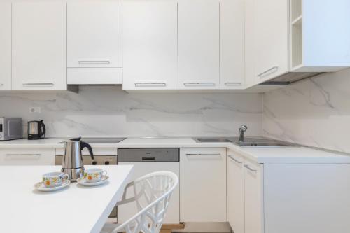 米蘭的住宿－JOIVY Minimalistic flat near the centre，厨房配有白色橱柜和白色台面