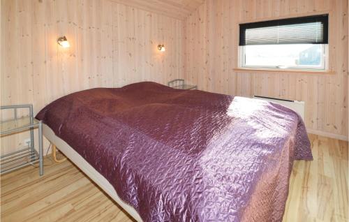 a bedroom with a bed with a purple blanket at Beautiful Home In Rdby With 4 Bedrooms, Sauna And Wifi in Kramnitse