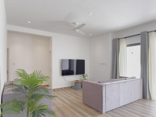 a living room with a couch and a tv at Résidence Coastal View - Privilege Appartement in the heart of Grand-Baie in Grand Baie