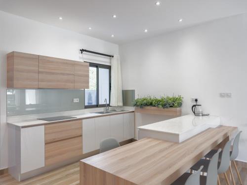 a kitchen with wooden cabinets and a wooden table at Résidence Coastal View - Privilege Appartement in the heart of Grand-Baie in Grand Baie