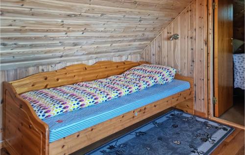 un letto in legno in una camera con parete in legno di 2 Bedroom Stunning Home In Rennesy a Hanasand