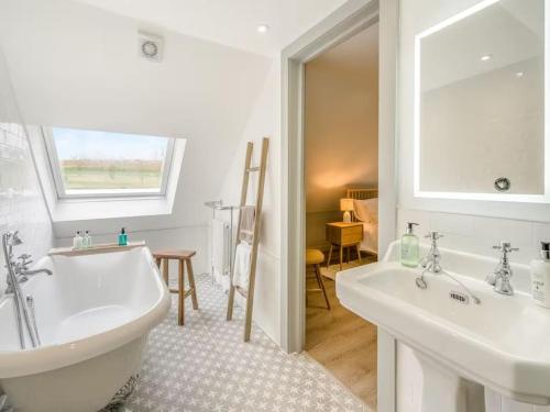 a bathroom with a tub and two sinks and a window at Blackside Cottage in stunning Ayrshire countryside in Mauchline